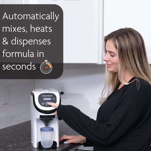 Woman operating white Formula Pro Mini portable formula maker on kitchen countertop - product thumbnail