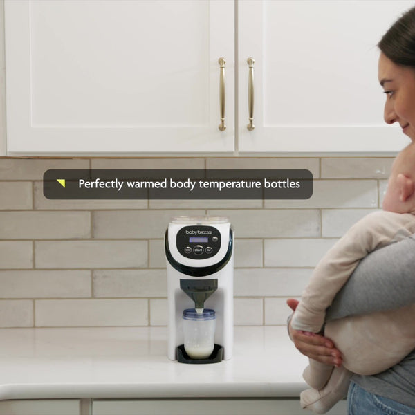 White Formula Pro Mini travel formula dispenser on counter with woman holding a baby looking at it. "Perfectly  warmed body temperature bottles" - product thumbnail