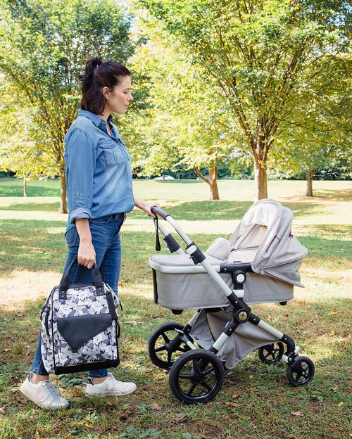 Woman carrying floral diaper bag while pushing stroller  - product thumbnail