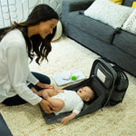Woman changing baby on the diaper bag changing station - product thumbnail