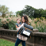 Woman holding baby while wearing trendy diaper bag - product thumbnail