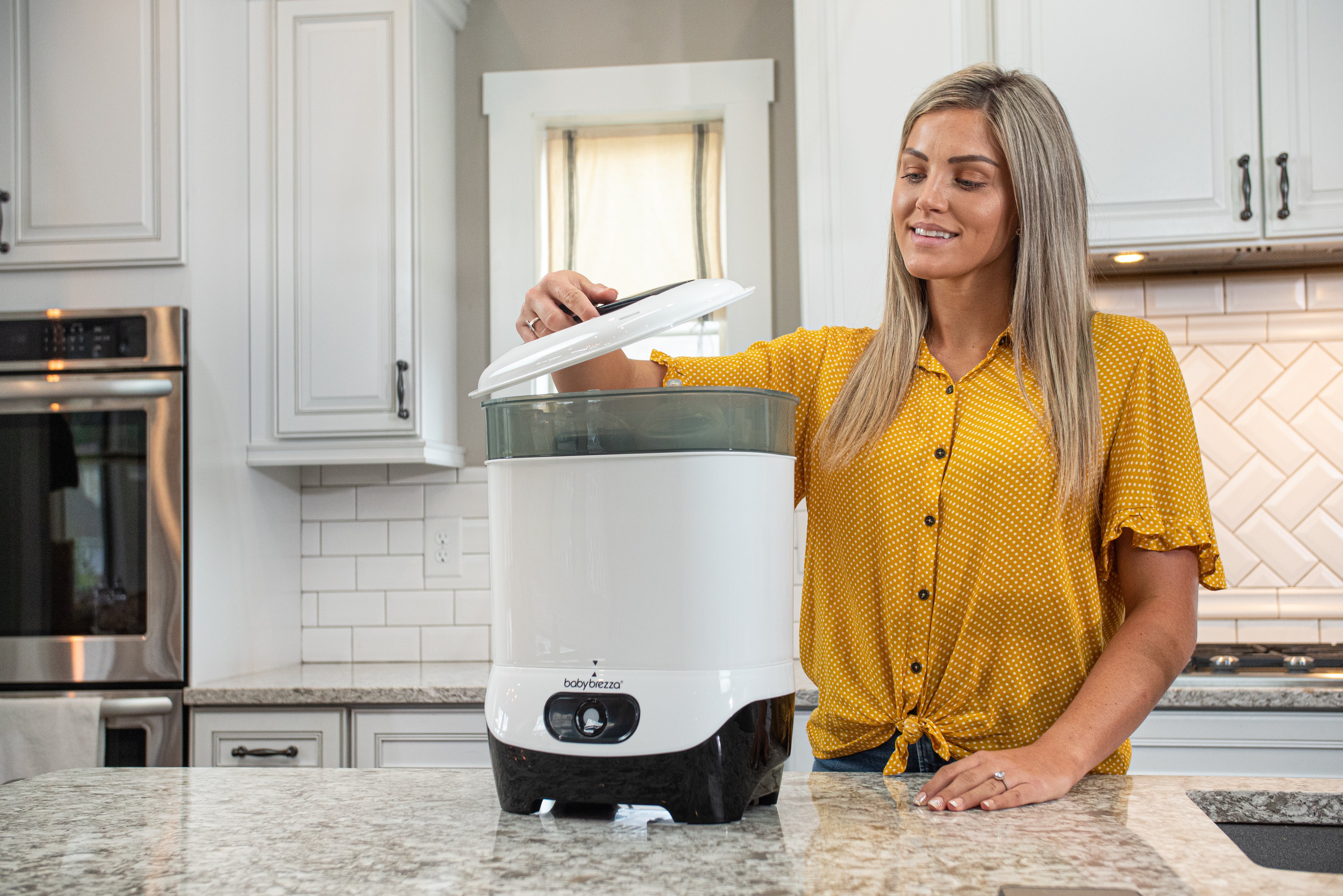 Mother Using a Bottle Sterilizer Dryer During Baby Safety Month