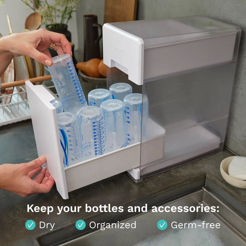 Baby Brezza Bottle drying rack with bottles on a kitchen counter, text indicating "Keep your bottles and accessories dry, organized, germ-free