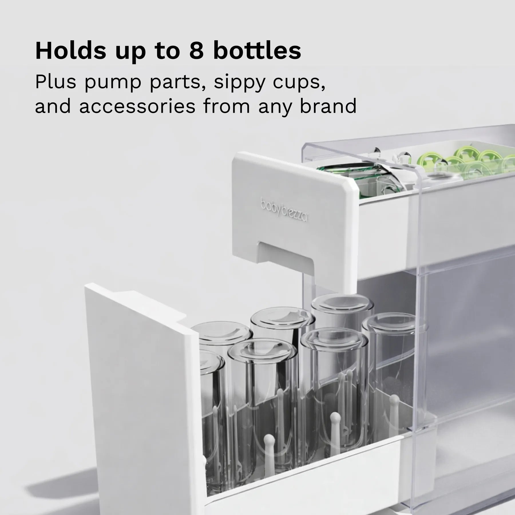 White drying rack drawer with bottles and pump parts on a light gray background, text indicating "Hold up to 8 bottles, plus pump parts, sippy cups, and accessories from any brand