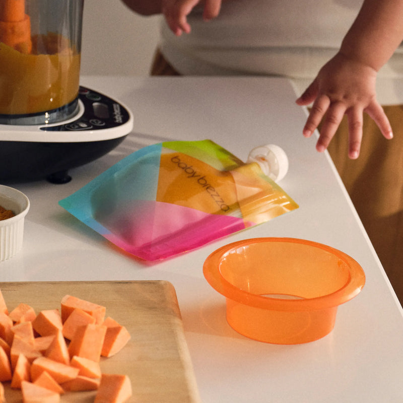 Person preparing sweet potatoes in the baby brezza one step food maker deluxe with puree in food pouch