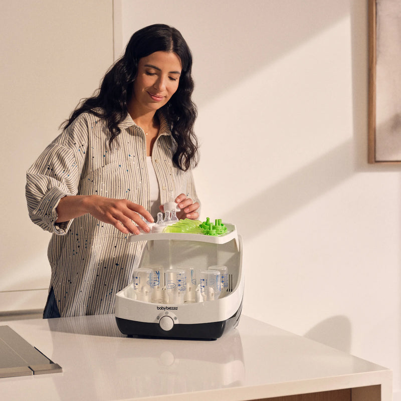 mom filling baby brezza superfast sterilizer dryer on kitchen island