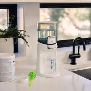 baby brezza instant warmer on a kitchen counter with a window in the background