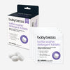 Baby Brezza bottle washer detergent tablets shown with retail packaging and three individual sachets on a light gray background. The box is white with a dark navy top flap and purple text, and the sachets are white with matching purple branding and a tablet illustration.
