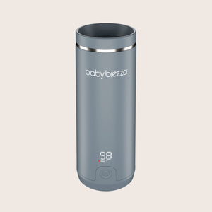 Gray baby brezza superfast portable travel bottle warmer with digital display on a beige background