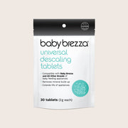 Baby Brezza Universal Descaling Tablets in a white and black resealable pouch with a teal logo and text, shown on a light beige background.