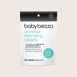 Baby Brezza Universal Descaling Tablets in a white and black resealable pouch with a teal logo and text, shown on a light beige background.