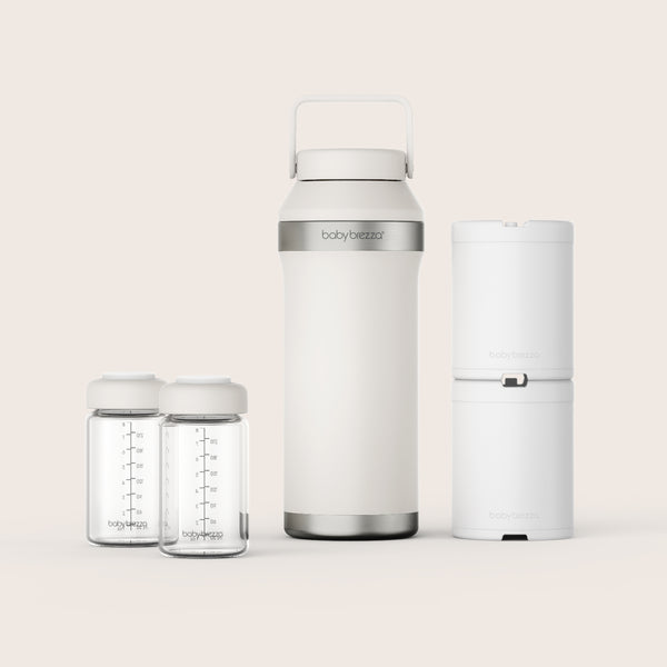 Baby Brezza portable breastmilk cooler and storage set on a light beige background with two white ice packs and glass storage bottles
