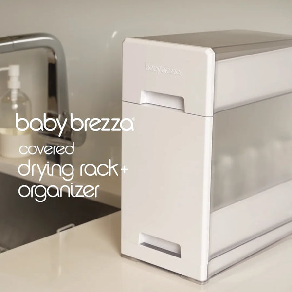 Load video: Upgrade how you dry and store your bottles, pump parts, and accessories with the Baby Brezza Covered Drying Rack and Organizer. Holds up to 8 bottles.  Quick drying with perforated bins. Drip tray slips out easily. Elevate your countertops while keeping your baby products organized, dry, and protected from germs.