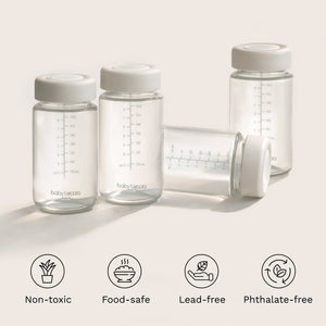 Clear baby bottles with white lids on a light background, featuring icons and text about safety features. Non-toxic, food-safe, lead-free, phthalate-free