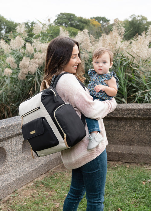 Woman holding baby wearing the best diaper bag - product thumbnail
